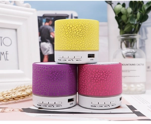 Close-up of portable crackle-patterned speakers with USB port and LED light in detail