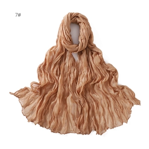 Detail view of light brown scarf featuring natural crinkle texture and soft gauze fabric