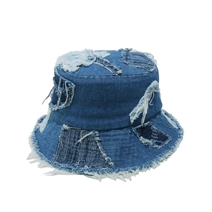 Detail of distressed patchwork denim bucket hat with fringe edges and retro street style