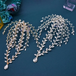 Macro detail of leaf-shaped bridal headbands with sparkling crystal teardrop pendants