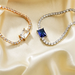 Elegant gold and silver square zircon bracelets on soft silk background