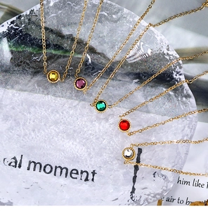 Detailed close-up of rainbow crystal necklace set with 18K gold plating on ice props