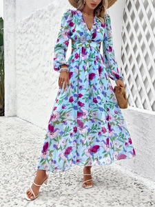 Détail de robe longue fleurie bleue avec col en V et découpe à la taille élégante