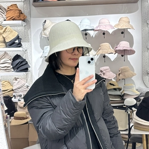 Mirror selfie showing the light green knit bucket hat paired with a black jacket