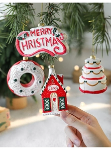 Close-up of candy-themed Christmas ornaments hanging on a pine branch with bokeh