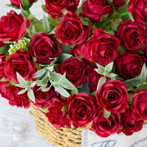 Detailed close-up of artificial red roses in a woven straw basket for home decor