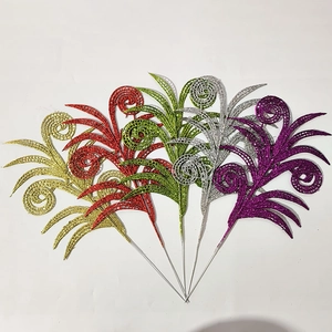 Macro detail of glitter-coated Christmas leaf ornaments in five festive colors