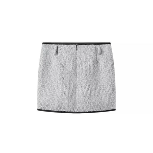 Detail view of the back of a grey tweed mini skirt with black piping and rear zipper