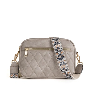 Quilted gray crossbody camera bag with retro embroidered shoulder strap on white background