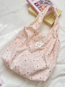 Pink floral tote bag with sweet flower pattern and shoulder strap on aesthetic books