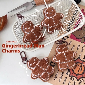 Cute brown gingerbread man plush keychains with white embroidery in a cream-toned scene