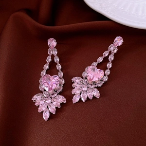 Makroaufnahme von eleganten rosa Zirkon-Herzohrringen in Silber auf dunkler Seide