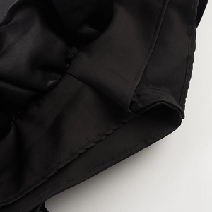 Close-up of clean stitching and high-quality black fabric texture on the ruffle dress