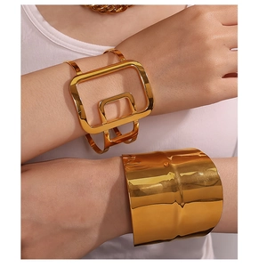 Detailed shot of gold geometric open cuff and wide ripple textured bracelet set