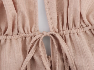 Détail de l'ensemble de vacances rose poudré avec tissu texturé et taille froncée