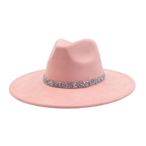 Detail of light pink fedora hat featuring a wide brim and sparkling silver rhinestone band