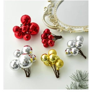 Detailed view of red, gold, and silver Christmas berry clusters on a white backdrop