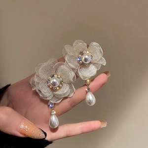 Detail of floral mesh earring with faux pearl center and crystal tassel drops