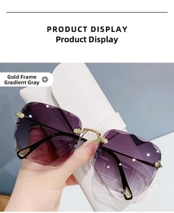 Detailed close-up of rimless gradient grey sunglasses with gold metal temples and cut edges