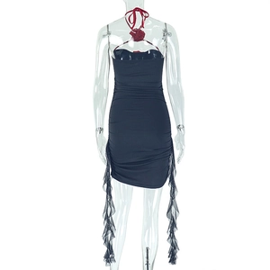 Détail de mini-robe moulante avec dos nu, licou, fleur rouge et volants latéraux délicats