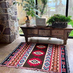 Detail of bohemian woven camping blanket with geometric patterns and fringe edges