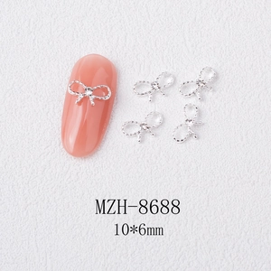 Detail of 10x6mm silver bow nail charm with rhinestone on a pink manicure display