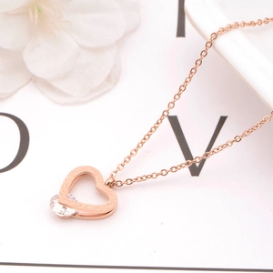 Detail of rose gold heart pendant necklace featuring a sparkling round zircon stone