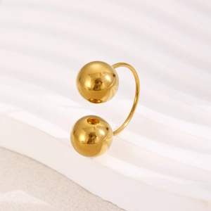 Macro view of gold stainless steel spherical ring on white textured display stand