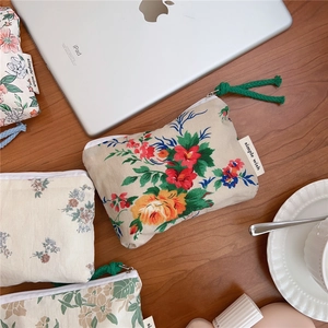 Flat lay of vintage floral cotton pouches with colorful pull tabs on a wooden desk
