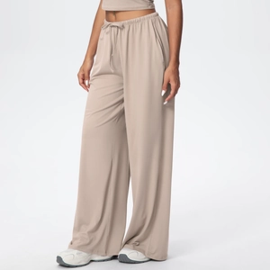 Detail of light beige wide-leg sweatpants with drawstring elastic waist and side pockets
