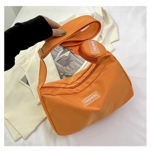 Detail of orange nylon shoulder bag with wide strap and matching round coin purse