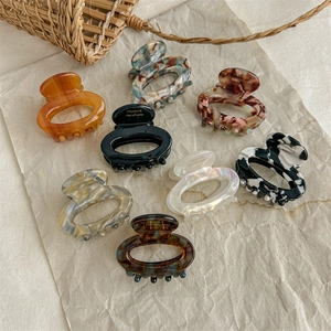 Set of 8 colorful resin oval hair claws with marble patterns and handmade gold logo