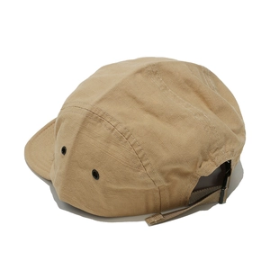 Detail of khaki five-panel camp cap showing side metal eyelets and adjustable strap buckle