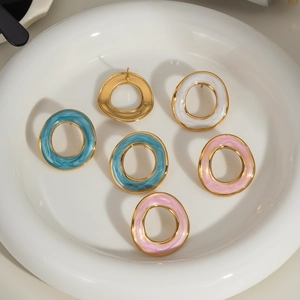 Boucles d'oreilles émaillées bleu blanc et rose sur une assiette en céramique