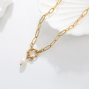 Macro detail of 18K gold-plated chain featuring a spring clasp and fresh water pearl pendant