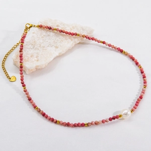 Macro detail of handmade necklace with faceted rhodochrosite beads and a white pearl