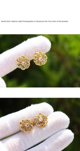 Detailed macro shot of a gold flower earring with light blue stones and white zircon
