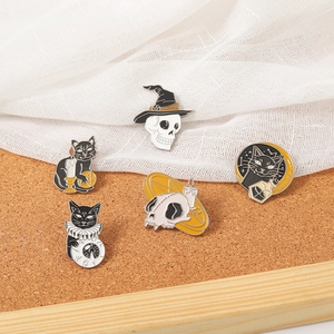 Spooky Halloween enamel pin set with black cat, skull and moon on a white background