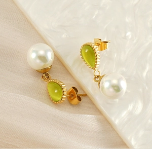 Detailed shot of teardrop green opal and white pearl earrings with gold-tone hardware