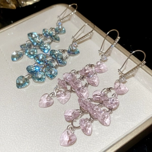 Detail of blue and pink heart crystal tassel earrings on a luxury jewelry tray