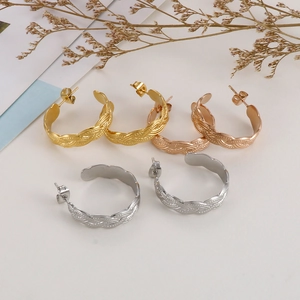 Detailed view of woven texture hoop earrings in gold, rose gold and silver finishes