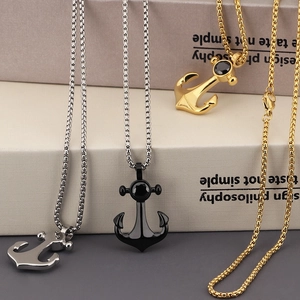 Three nautical anchor necklaces in silver, black and gold finishes on gift boxes