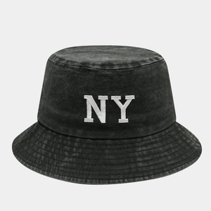 Détail de la broderie blanche NY sur un chapeau bob en coton noir délavé vintage