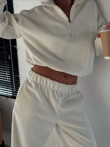 Detail of soft cream polar fleece fabric on half-zip sweatshirt and drawstring joggers