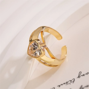 Close-up of heart-shaped zircon gold ring on a white textured background with soft lighting