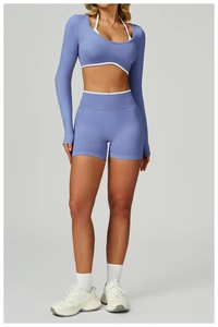 Detail of blue high-waist seamless yoga set featuring white piped cropped top and shorts