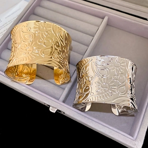 Detail of gold and silver open bangles with embossed floral and paisley patterns