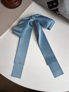 Détail d'une barrette à nœud en satin bleu avec de longs rubans élégants