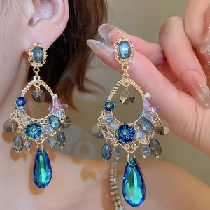 Detailed view of elegant drop earrings with blue floral crystals and gold-toned filigree