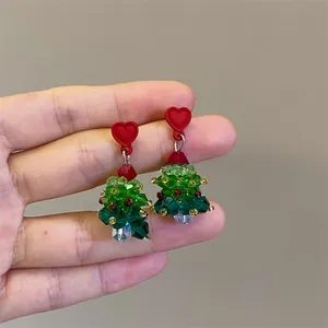 Detail of handmade beaded Christmas tree earrings with red heart studs and crystals